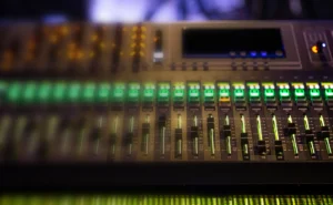 Audio mixing console with illuminated sliders and knobs, representing audio visual technology for corporate events in Nashville.