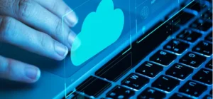Hand hovering over laptop keyboard with a blue cloud icon, symbolizing cloud computing and managed IT services for cybersecurity in Nashville businesses.